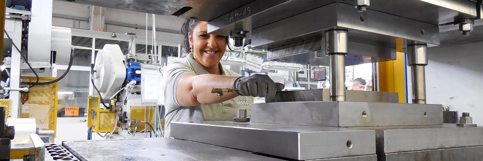 Woman operating a hydraulic press in an industrial workshop